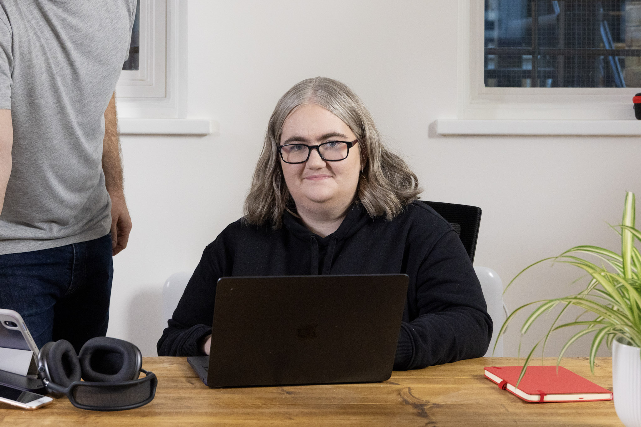 a photo of Dr Katie Paxton-Fear sitting at a desk with a laptop, tablet and headphones