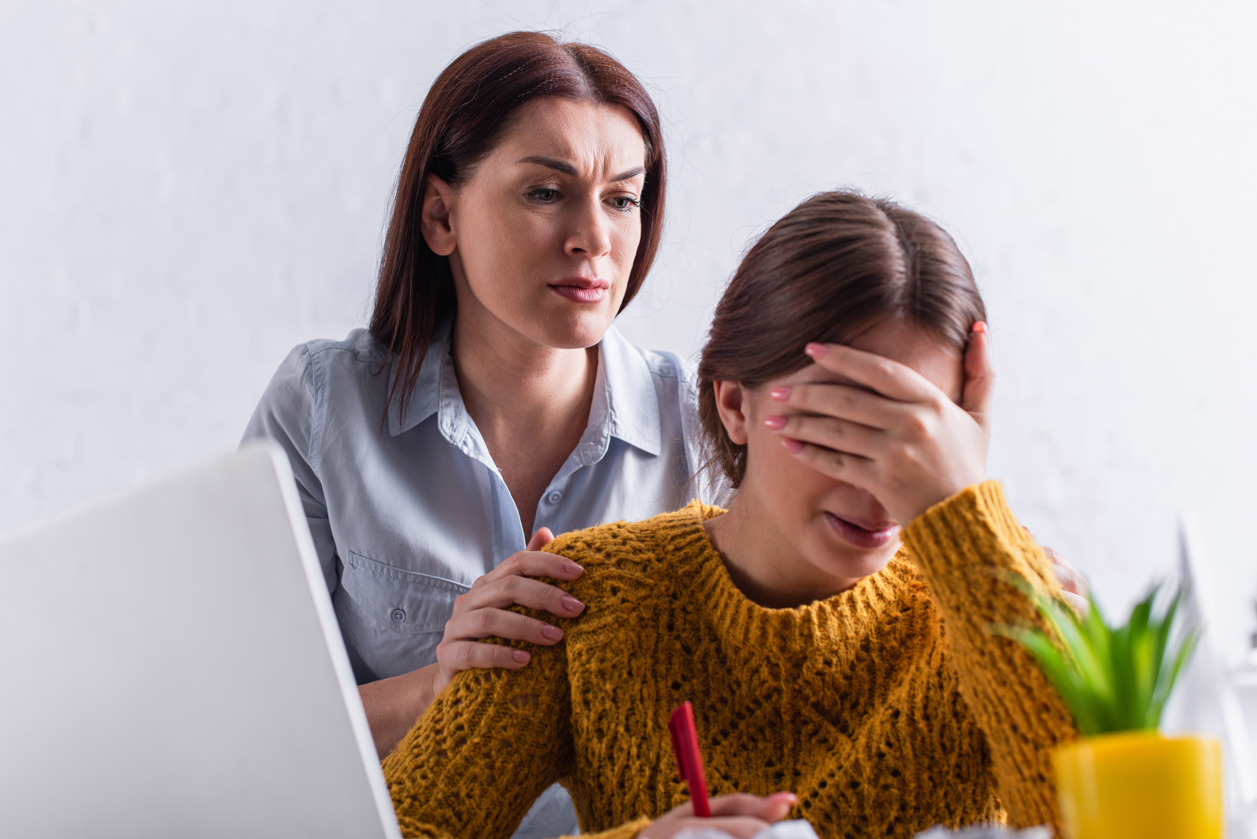 A stock image of a worried mother hugging her upset teenage daughter.